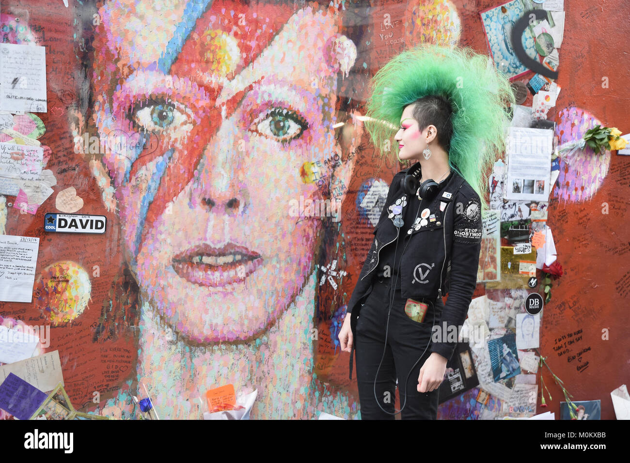 Punk Lady neben der Aladdin Sane Wandbild in Brixton, am zweiten Jahrestag von David Bowie's Tod am 10.01.2016, Brixton, London, UK Stockfoto