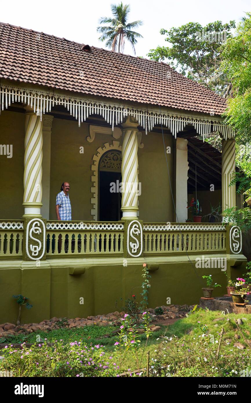 Indien, Goa, Mann in den Kolonnaden Terrasse seines grünen kolonialen Portugiesisches Haus Stockfoto