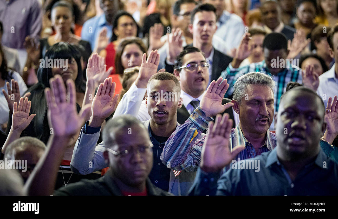 West Palm Beach, Florida, USA. 23 Jan, 2018. David Obadimeji, Nigeria, (Mitte), gibt seinen Eid der Treue zu den Vereinigten Staaten. Mehr als 500 Menschen wurden als neue US-Bürger an der South Florida Messe am Dienstag geschworen, 23. Januar 2018. Die staatsbürgerschaft Bewerber kamen aus 65 Ländern. Credit: Allen Eyestone/der Palm Beach Post/ZUMA Draht/Alamy leben Nachrichten Stockfoto