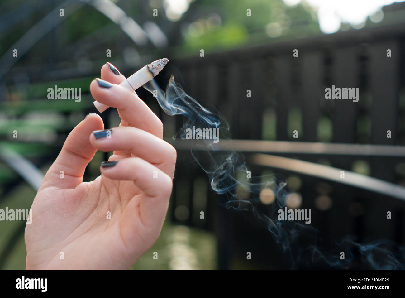 Frau Hand eine Zigarette mit Rauch Stockfoto