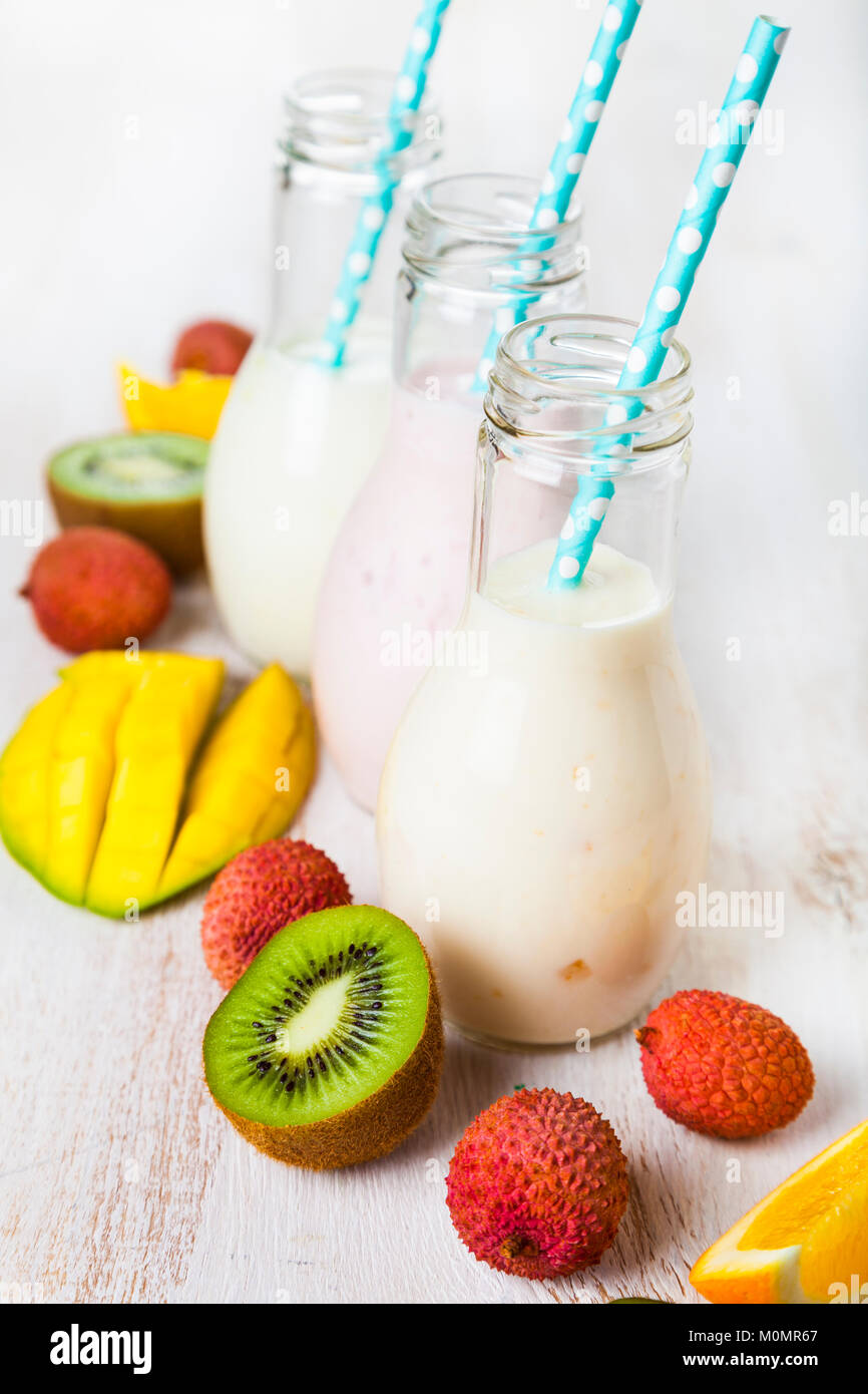 Smoothies mit tropischen Früchten auf einem hölzernen Hintergrund. Leckeres Frühstück. Das gesunde Essen. Stockfoto