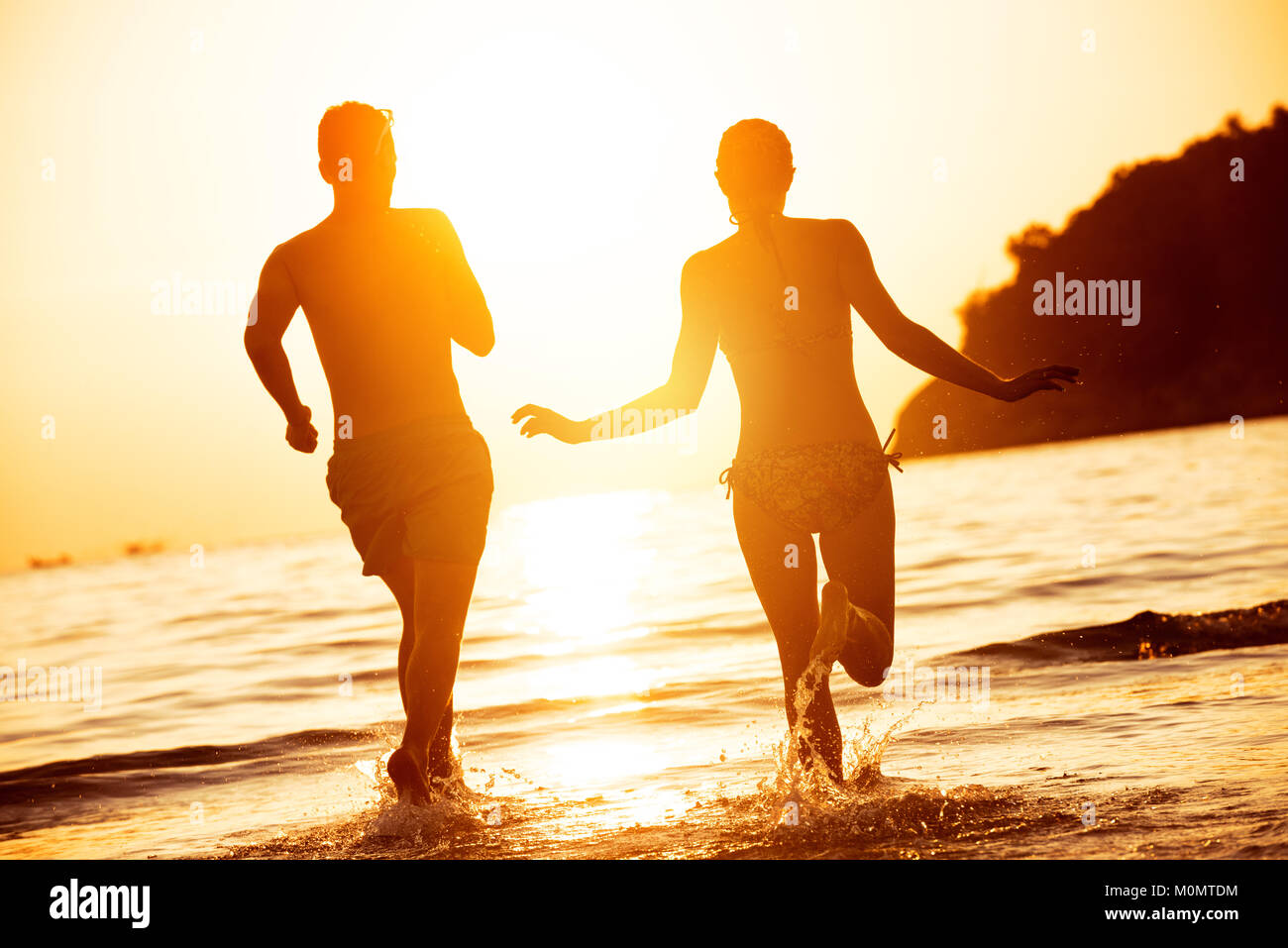 Glückliches Paar laufen Meer bis Sonnenuntergang Stockfoto