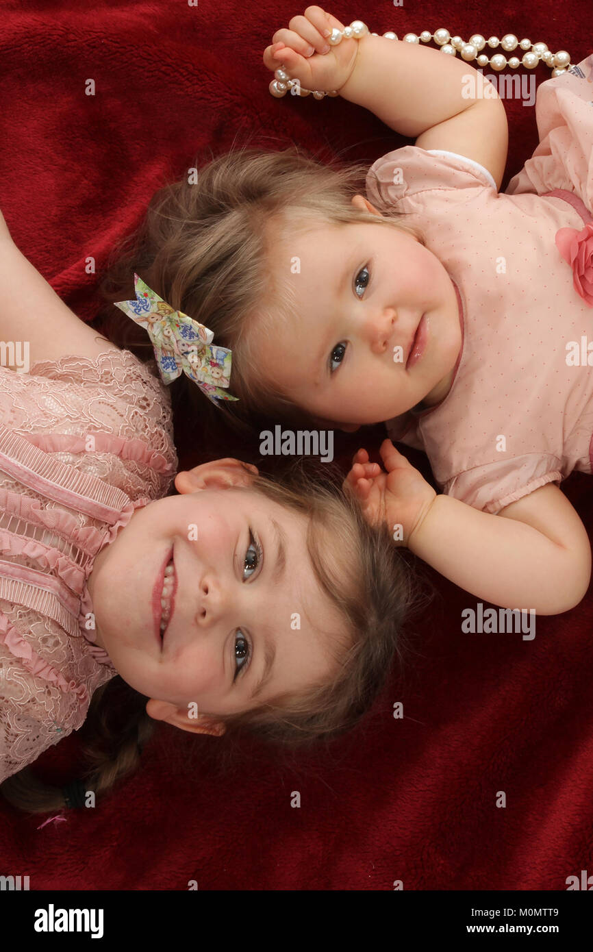 2 Mädchen auf Decke Schwestern liebevolle Familie Stockfoto