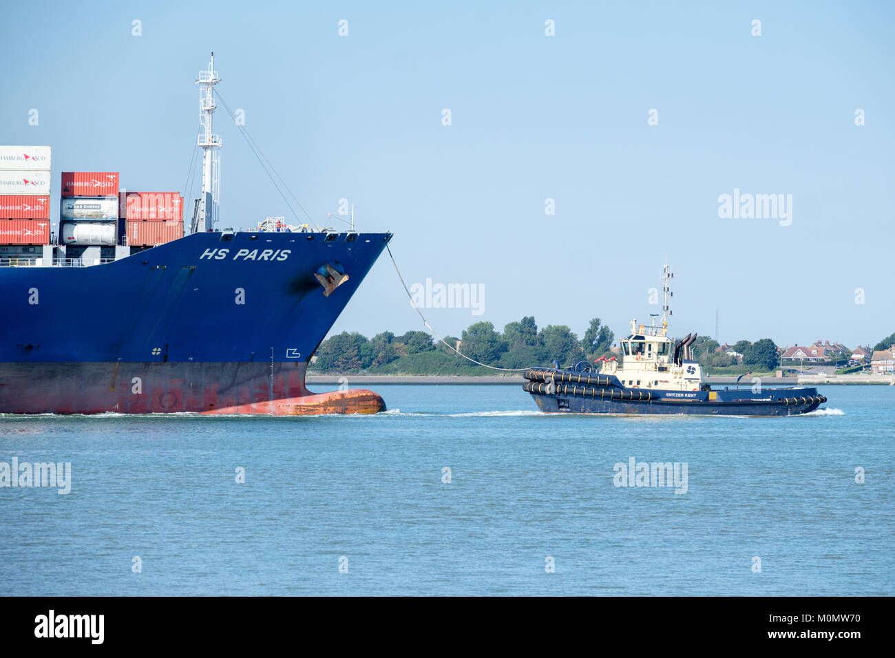 Damen ASD 3212 Tug (svitzer Kent) Führen der Hansa Shipping Company Containerschiff. HS PARIS in den Hafen von Felixstowe, England, Großbritannien Stockfoto