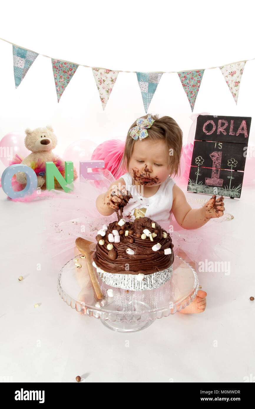 1-Jähriges Mädchen Geburtstag, Kuchen Smash, unordentlichen Schokolade Kuchen Stockfoto