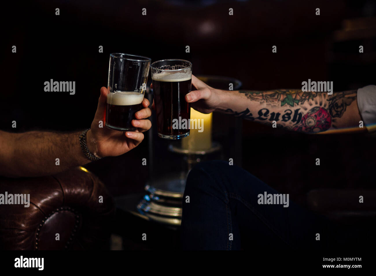 Nahaufnahme von zwei Männern toasten ihre Pints. Stockfoto