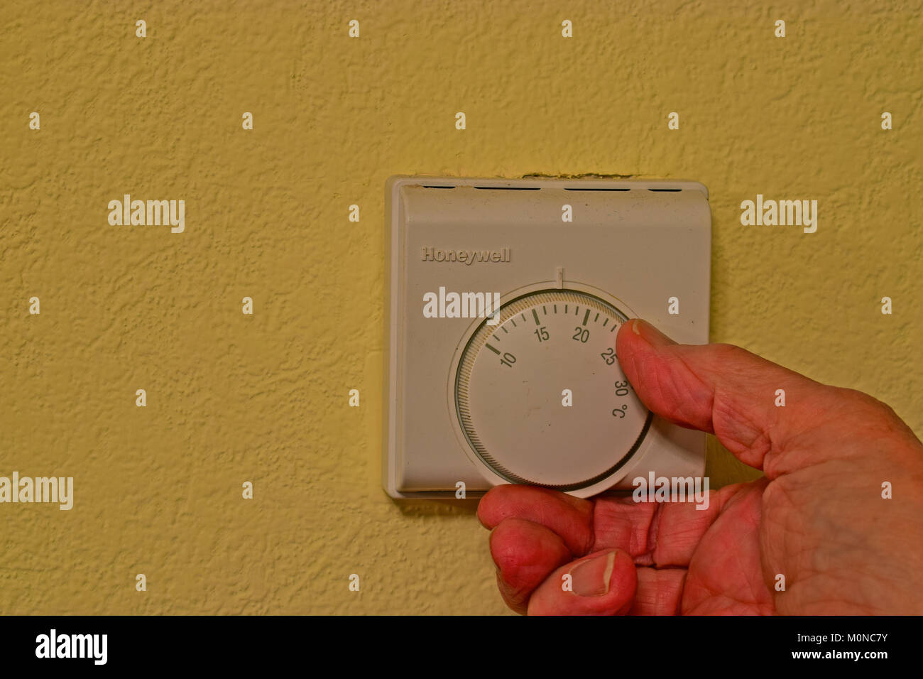 Drehen Sie den Thermostat um Geld zu sparen und es sich warm zu halten! Tipps, um Geld zu sparen, besonders im Alter, während noch warm zu halten. Stockfoto