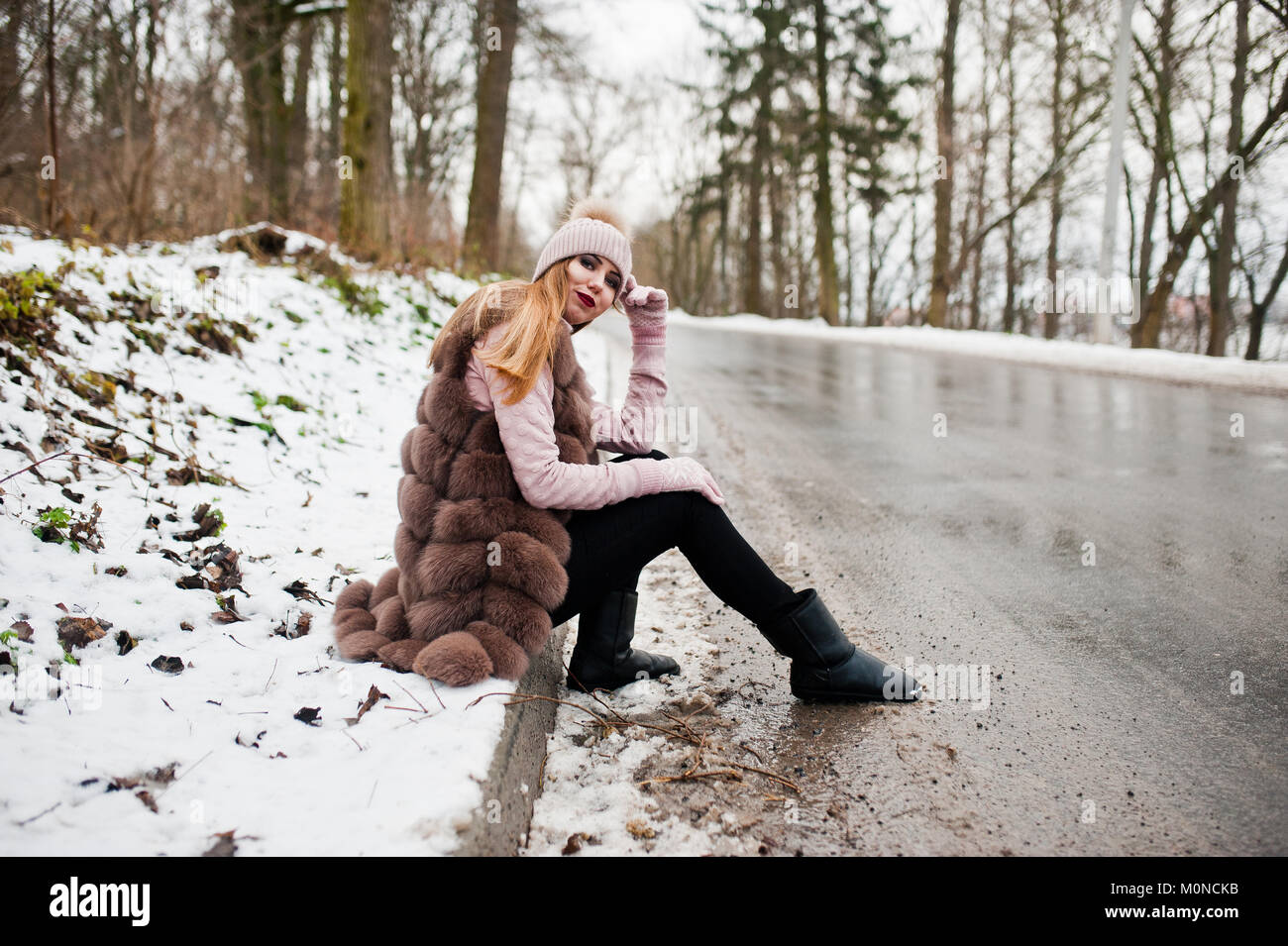 Stilvolle Mädchen im Pelzmantel und Kopfbedeckungen im Winter tag auf Sitzung Grenze ofroad. Stockfoto