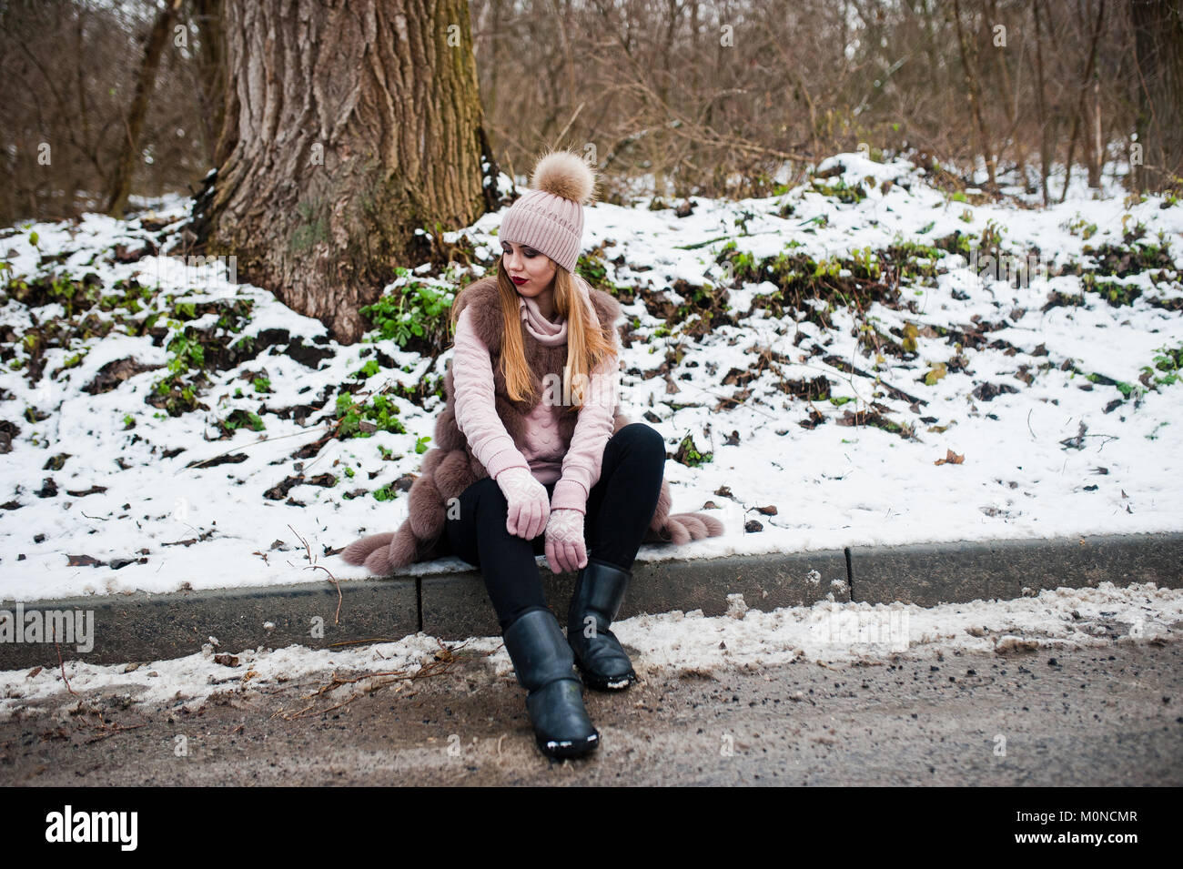 Stilvolle Mädchen im Pelzmantel und Kopfbedeckungen im Winter tag auf Sitzung Grenze ofroad. Stockfoto