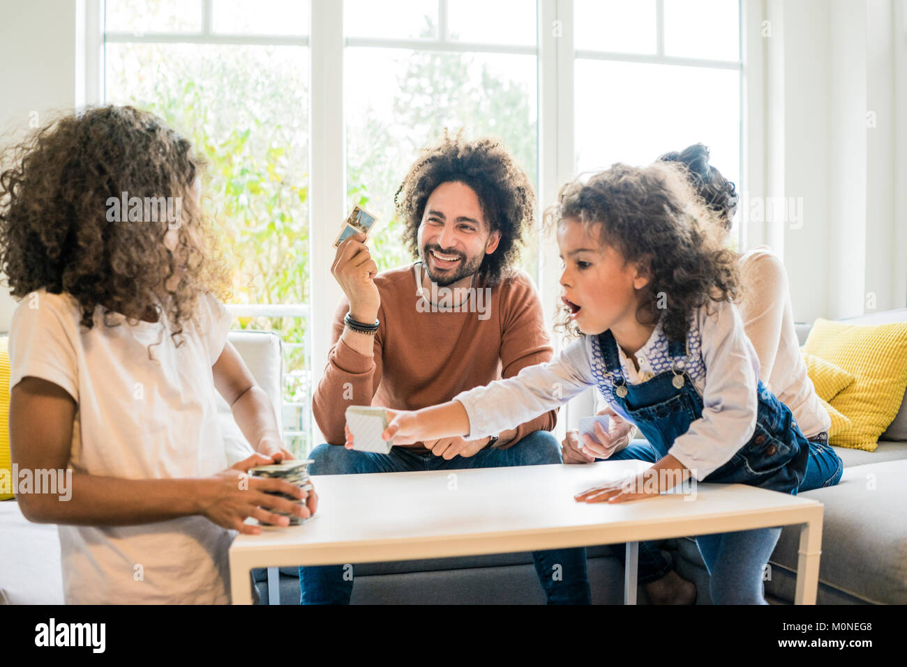 Familie sitzt auf der Couch und spielt Memory Spiel Stockfoto