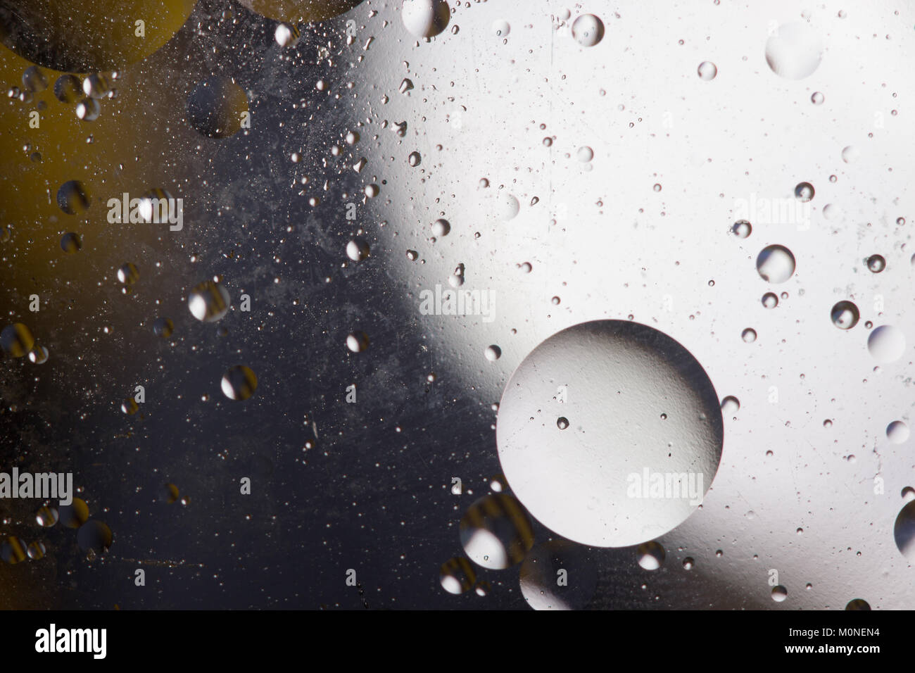 Öl Blasen im wässrigen Medium an der Grenze zu einer Glasoberfläche. Abstrakte Bildschirmschoner. Stockfoto