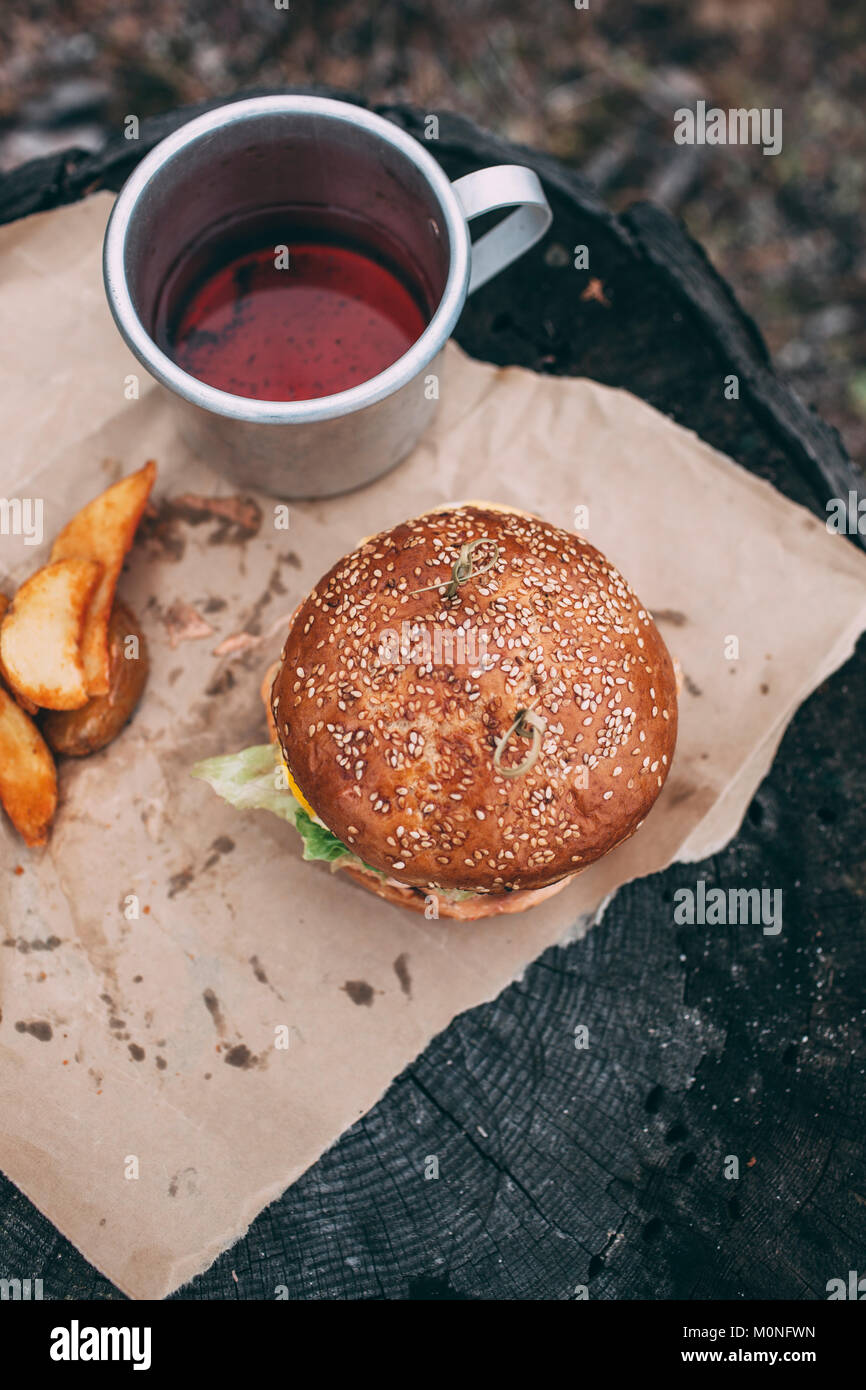 Burger und Becher mit Tee auf Briefmarke Stockfoto