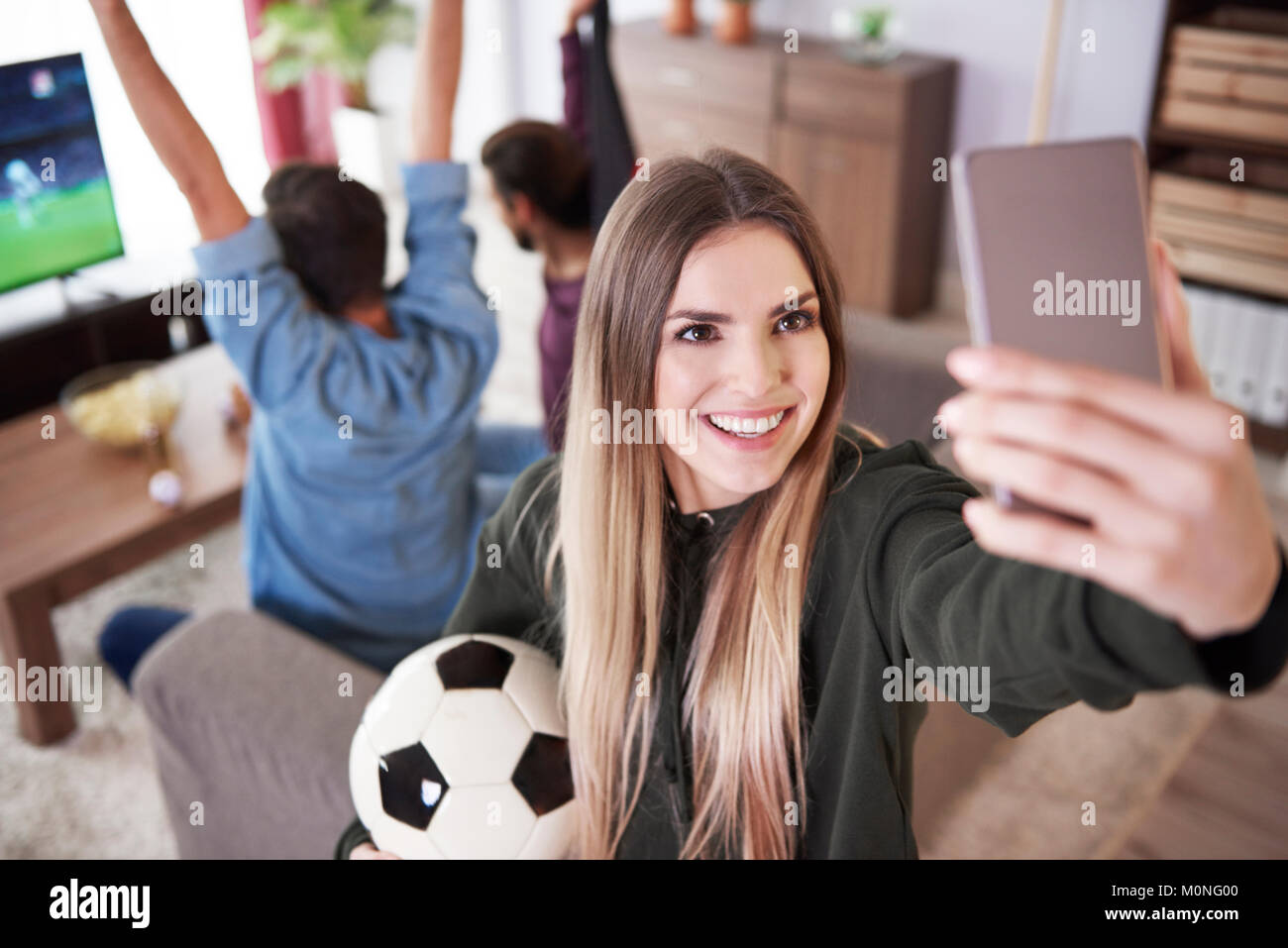 Weibliche Fußball-Fan ein selfie zu Hause Stockfoto