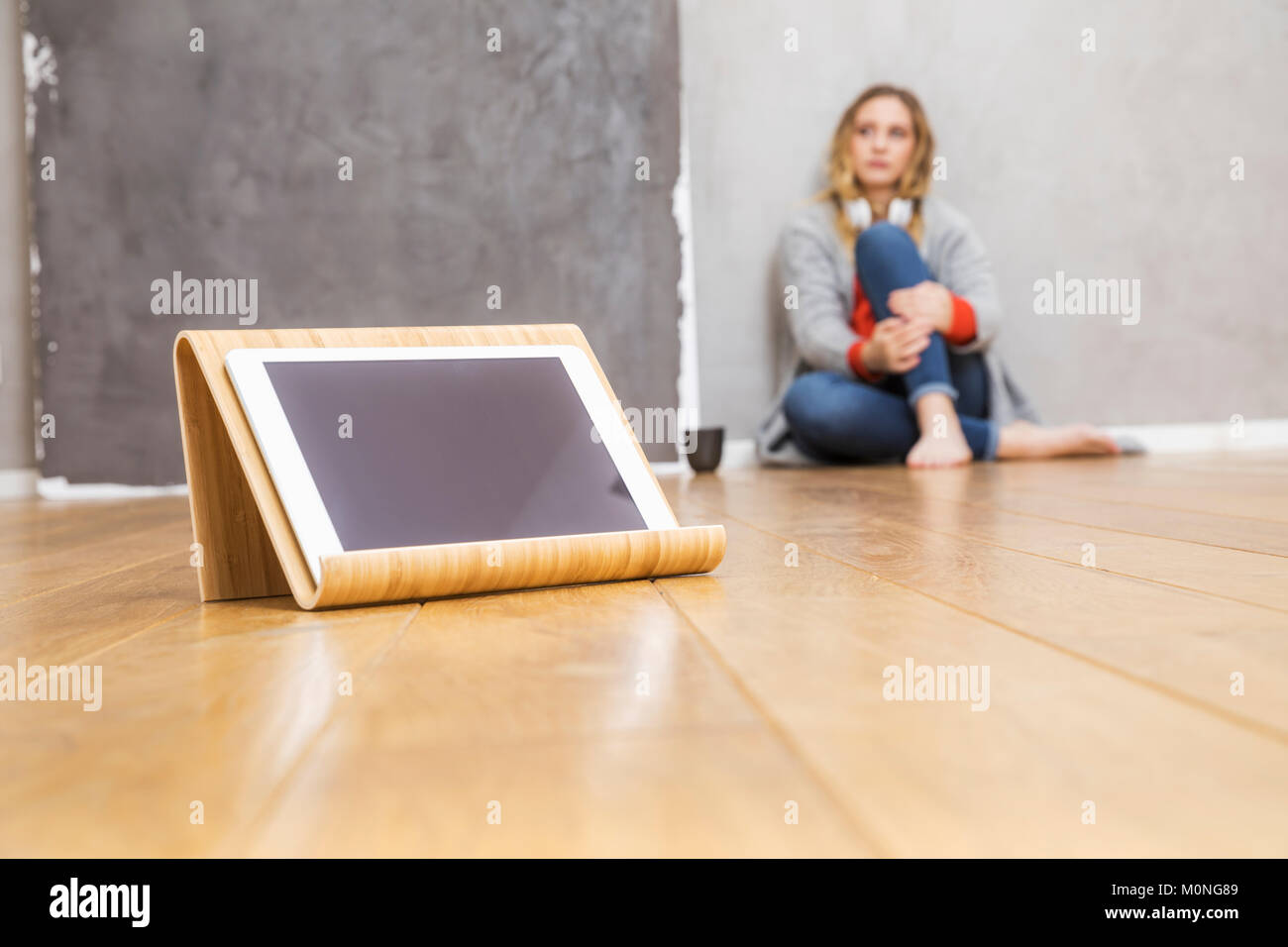 Tablet-PC Tablet auf dem Boden stehen mit jungen Frau im Hintergrund sitzen Stockfoto