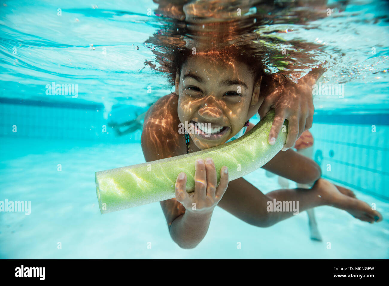 Porträt der lächelnde Mädchen mit pool Nudel unter Wasser im Pool Stockfoto