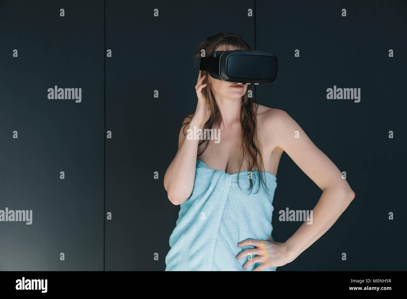 Frau eingewickelt in ein Handtuch tragen VR-Brille Stockfoto