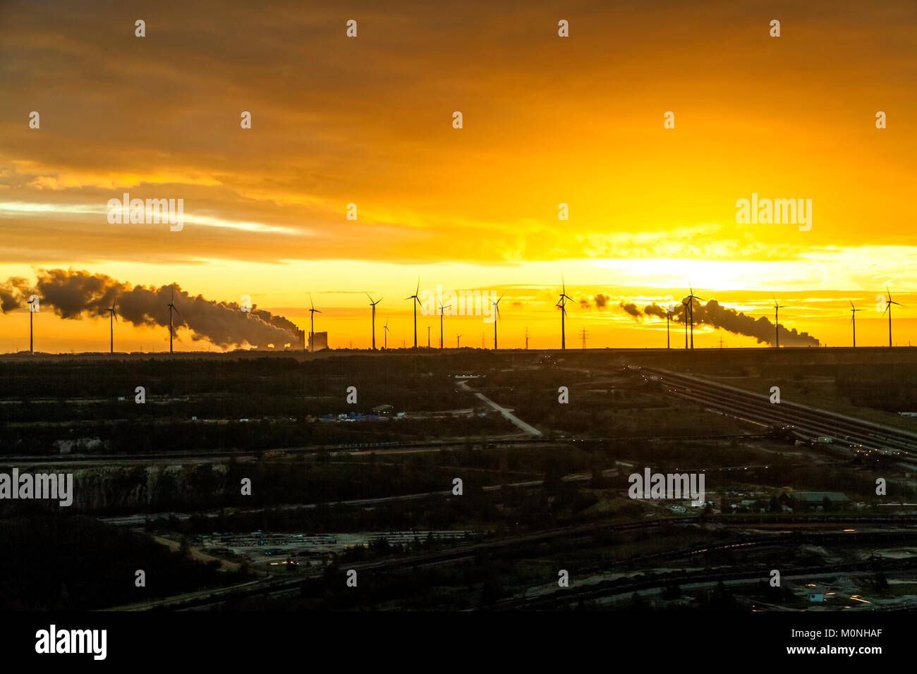 Deutschland, Nordrhein-Westfalen, Juechen, Garzweiler Oberfläche Mine bei Sonnenaufgang, Windpark im Hintergrund Stockfoto