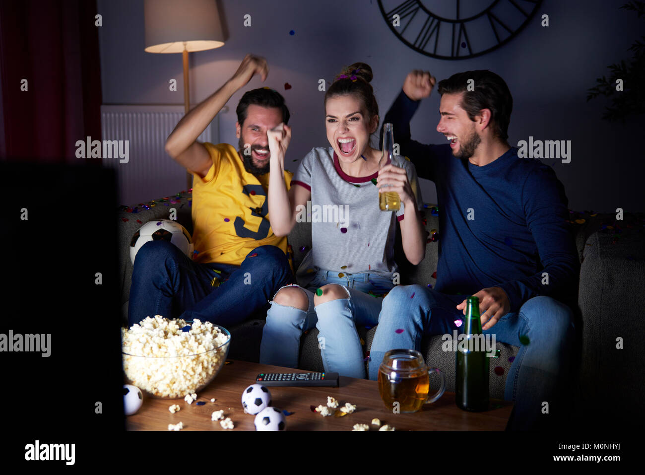 Aufgeregt Freunde sitzen auf dem Sofa Fernsehen Stockfoto