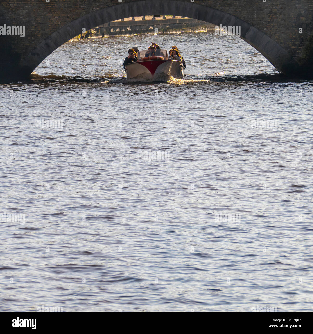 Touristenboot unter Brücke, Komposition mit viel Wasser für Kopie Raum, Brügge, Belgien Stockfoto