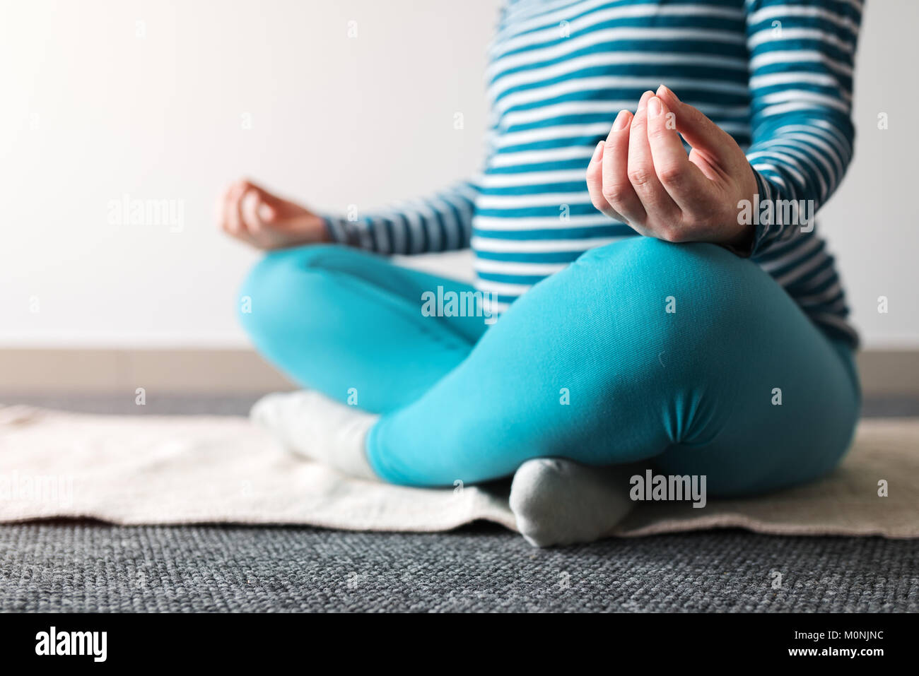 Schwangeren Yoga Übung zu Hause. Schwangerschaft Yoga und drinnen Fitness Concept. Unbenotete kontrastarmen Aufnahmen mit natürlichen Fenster Licht. Stockfoto