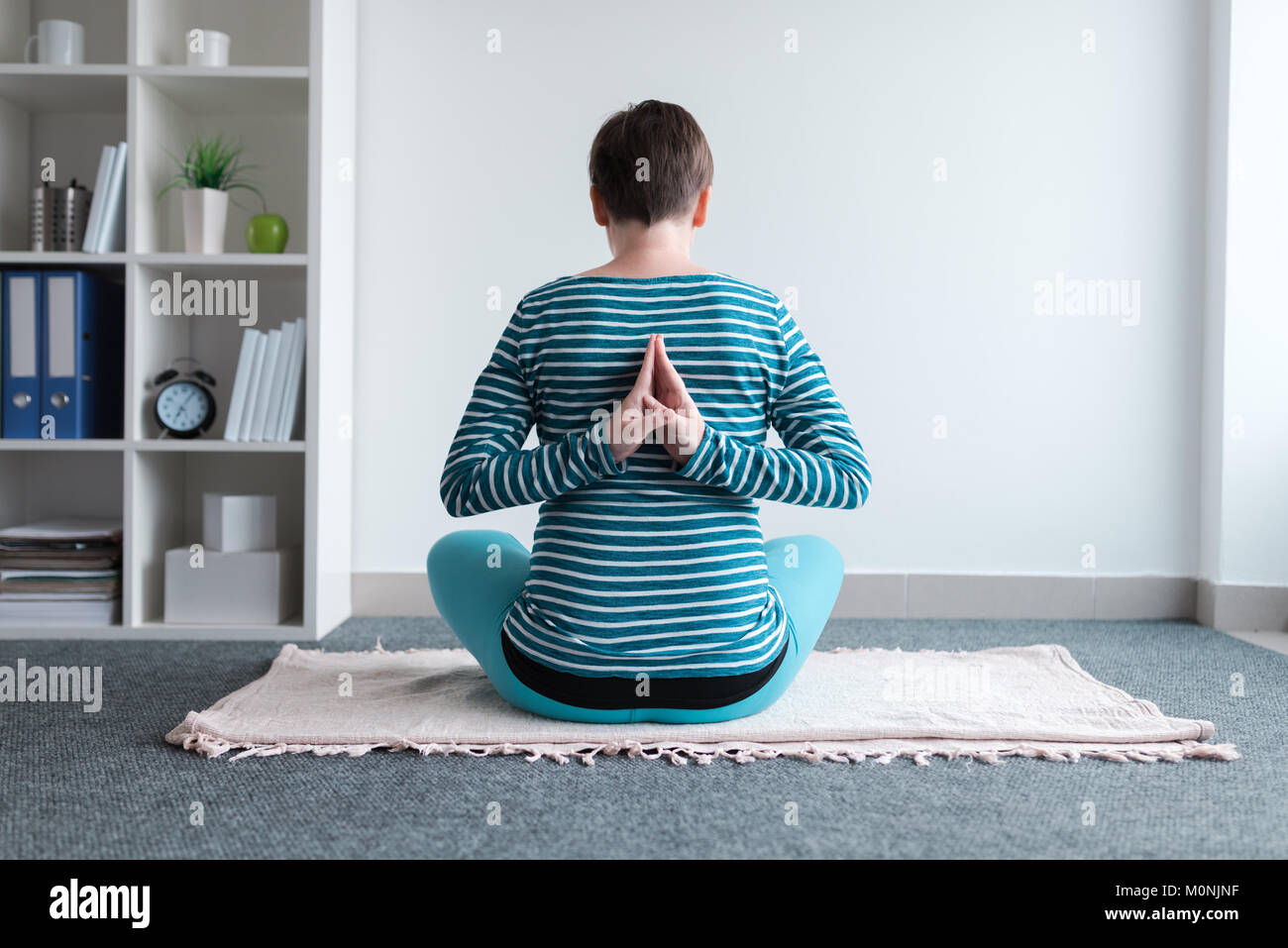 Schwangeren Yoga Übung zu Hause. Schwangerschaft Yoga und drinnen Fitness Concept. Unbenotete kontrastarmen Aufnahmen mit natürlichen Fenster Licht. Stockfoto