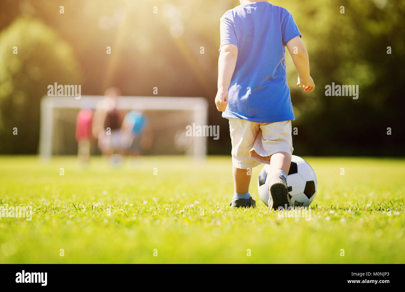 Kleine Jungen spielen Fußball auf dem Spielfeld mit Toren Stockfoto