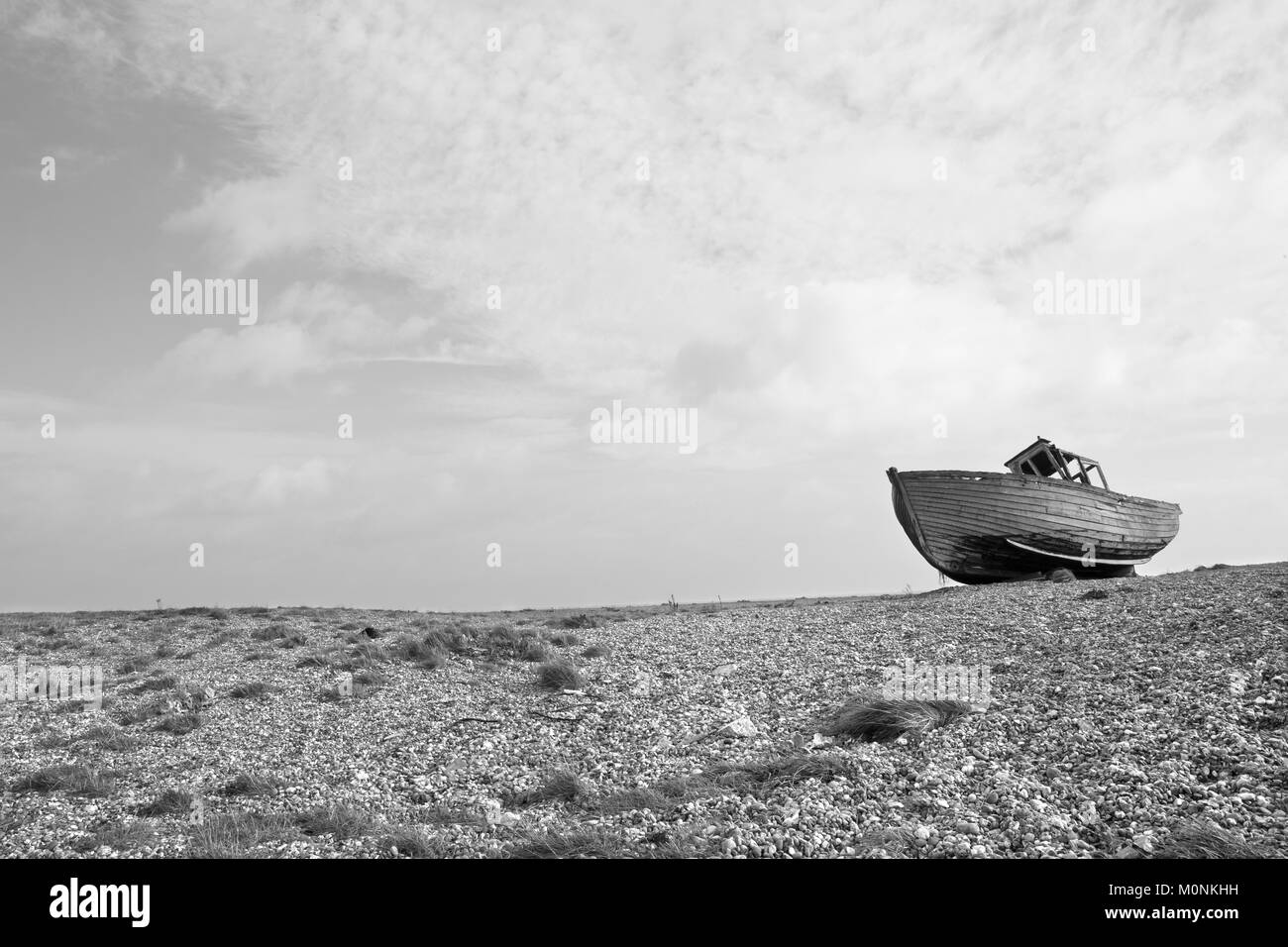 Alte zerstört Holz- shiplap Fischerboot auf Steinchen auf Dungeness Küste von Kent gewaschen. Alte havarierten Boot auf Buche Stockfoto