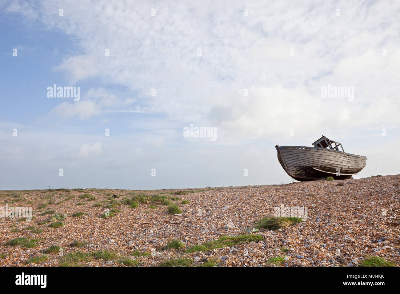 Alte zerstört Holz- shiplap Fischerboot auf Steinchen auf Dungeness Küste von Kent gewaschen. Alte havarierten Boot auf Buche Stockfoto