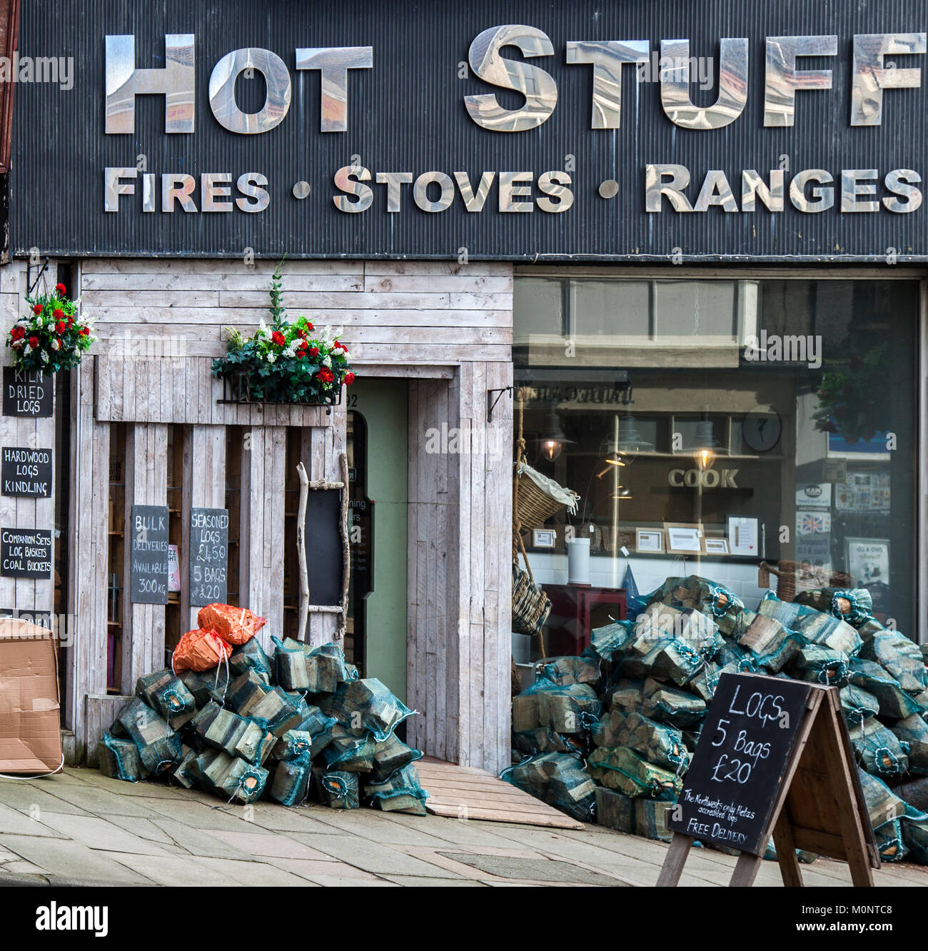 Hot Stuff Showroom-Shop, der Holzöfen, Bereiche, Holzstäbchen, verpackte Holzstämme, Heizgeräte und Anzünden für offene Feuer verkauft, Hoylake, Großbritannien Stockfoto