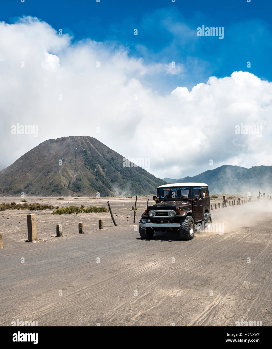 Off-road-Fahrzeug fährt durch die Tengger Caldera, hinter der Mt. Batok, Nationalpark Bromo-Tengger-Semeru, Java, Indonesien Stockfoto