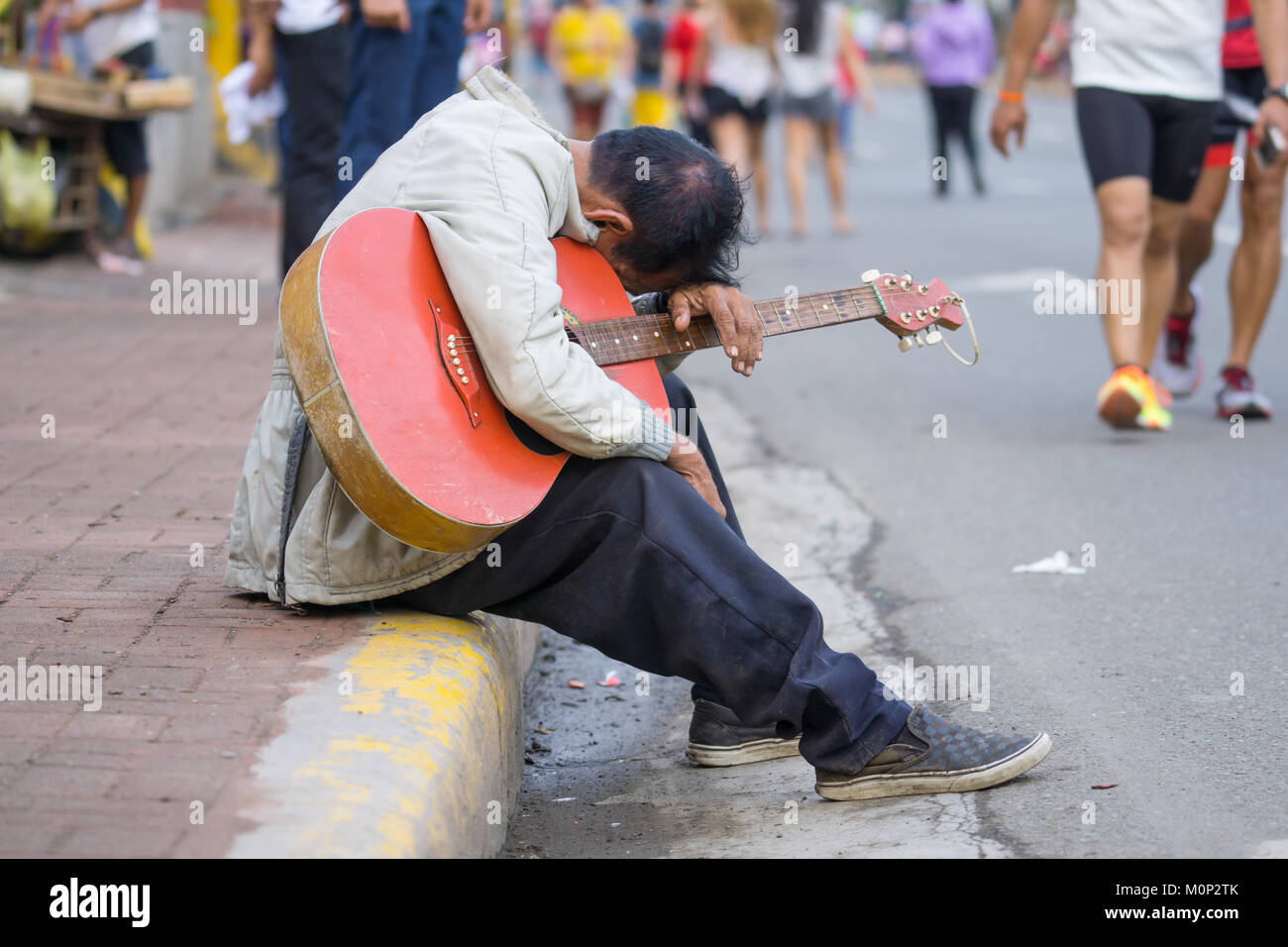 Der Mann mit der Gitarre in stürzte Position mit Kopf reasting auf seiner Gitarre während Sinulog Fest, Cebu City Stockfoto