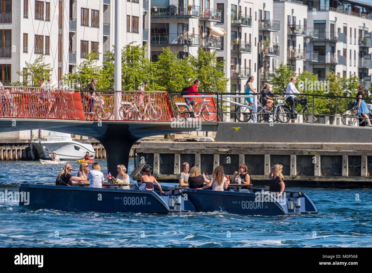 Dänemark, Seeland, Kopenhagen, junge Menschen auf Charter Boote vor der bewegliche Brücke, die Cirkelbroen (Kreis Brücke) in der Form von Olafur Eliassons Boot für die christianshavns Kanal Stockfoto