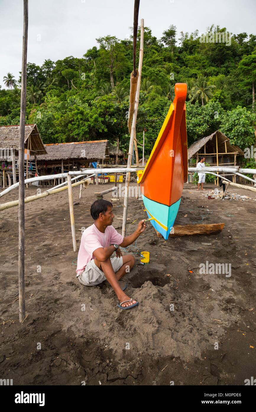 Philippinen, Luzon, Provinz Albay, Tiwi, mann Malerei seinem Fischerboot Stockfoto