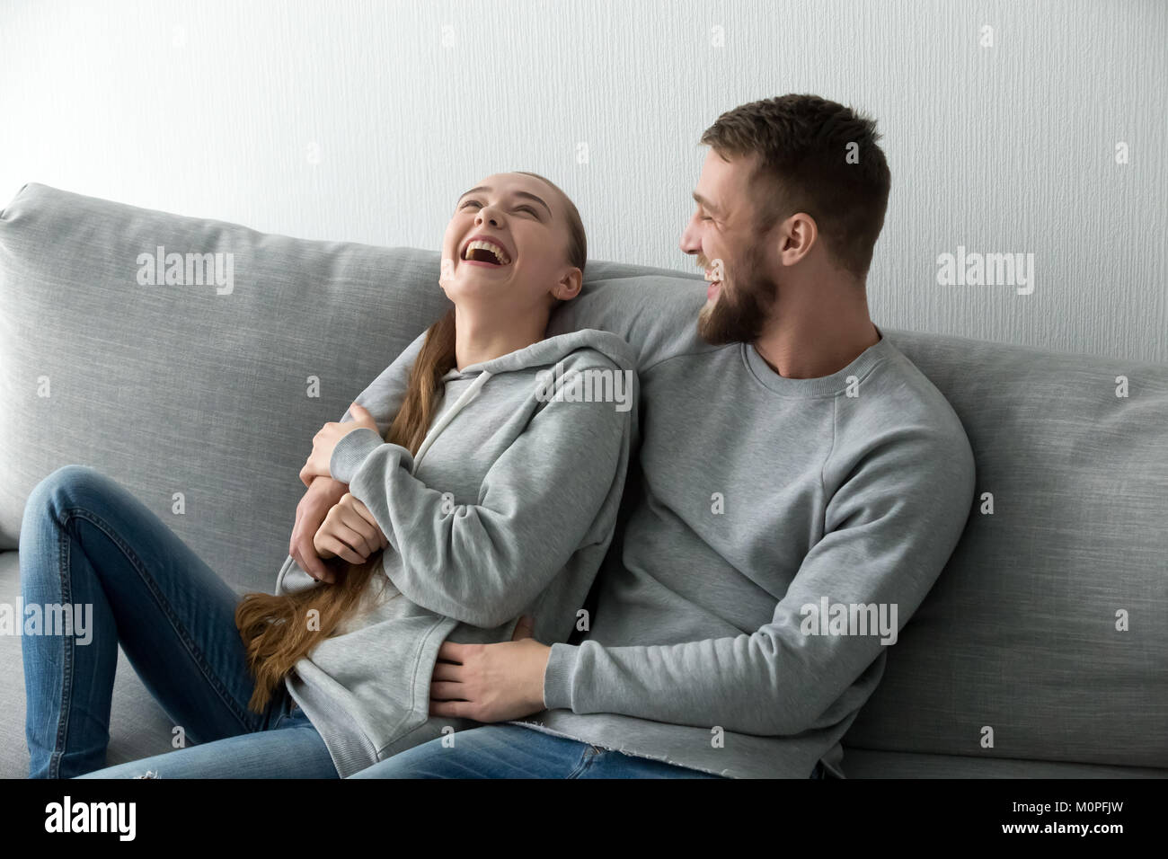 Junges Paar Spaß Lachen entspannt zu Hause auf der Couch Stockfoto