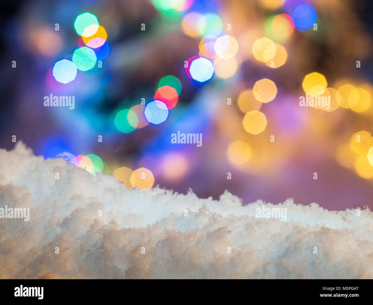 Schnee und bunte Weihnachtslichter im Hintergrund. Stockfoto