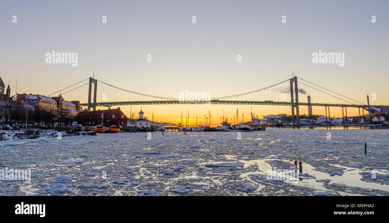 Göteborg - schönen Sonnenuntergang bei Frozen Gota Fluss mit Hisingsleden Brücke im Hafenviertel im Winter Stockfoto