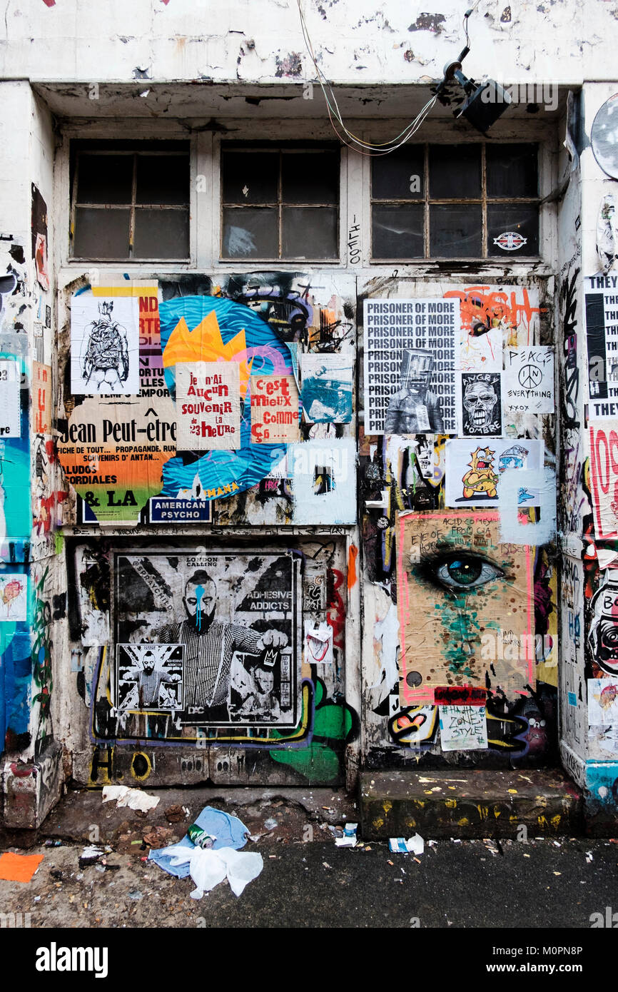 London urban Fotografie: Wand bedeckt mit Fliegen, Poster, Brick Lane, East London. Stockfoto