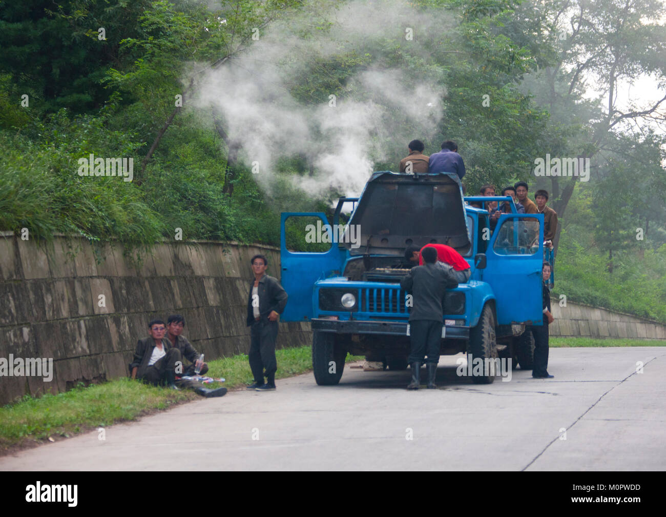 Die nordkoreanischen Männer Reparieren einer rauchen Dampf Lkw auf der Autobahn,Hwanghae Province, Chilbo Meer, Nordkorea Stockfoto