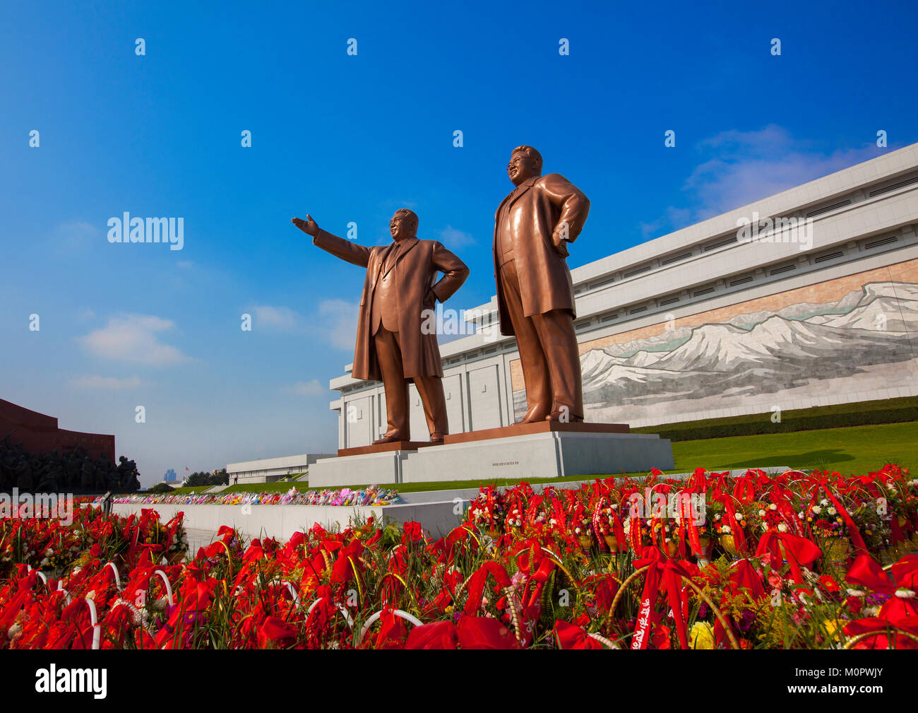 Körbe mit Blumen vor den beiden Statuen der Liebe Verantwortliche in der großen Denkmal auf Mansu Hill, Pyongan Provinz, Pyongyang, Nordkorea Stockfoto