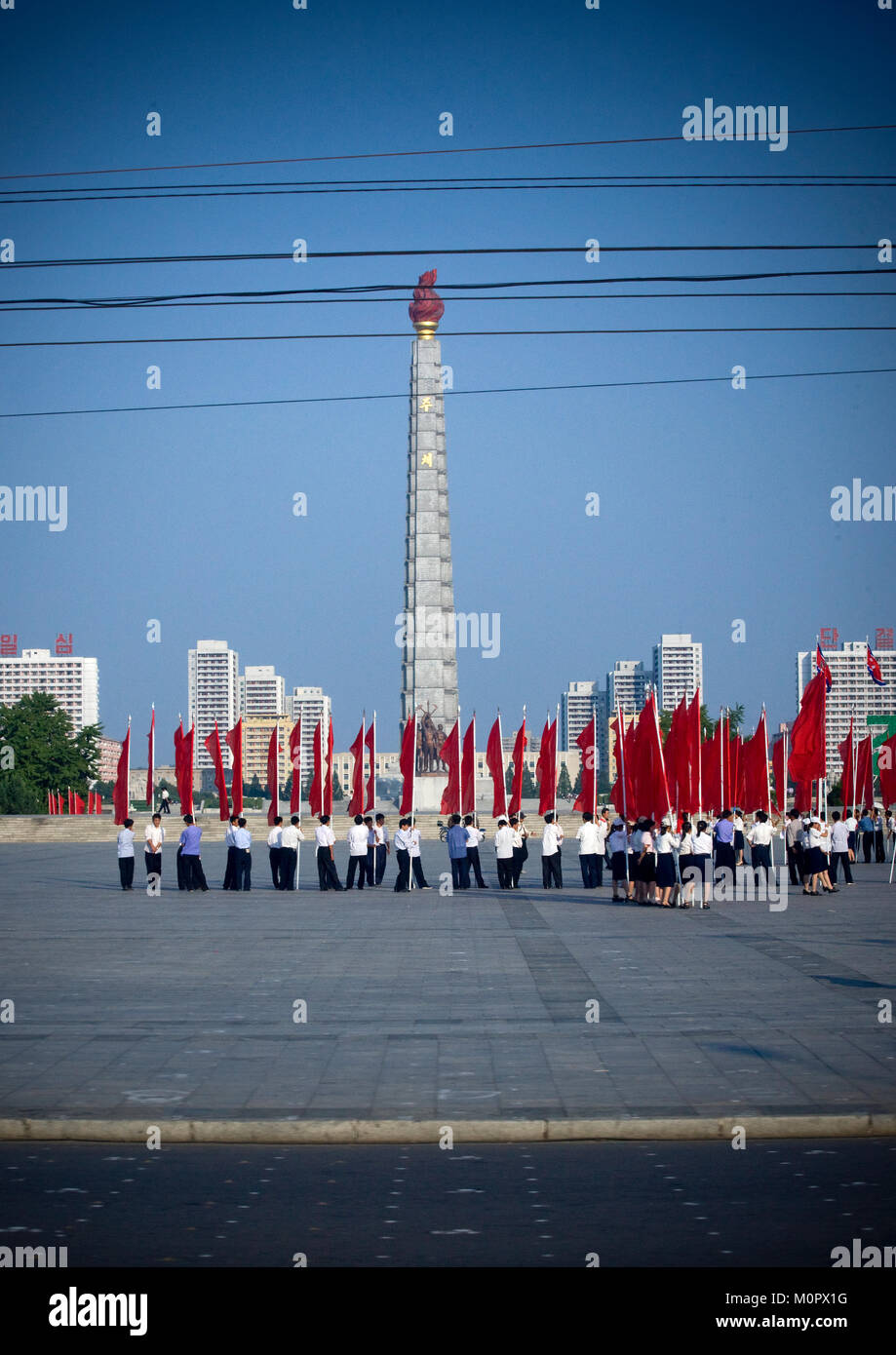 Nordkoreanische Menschen mit roten Fahnen vor der Juche Tower, Pyongan Provinz, Pyongyang, Nordkorea Stockfoto