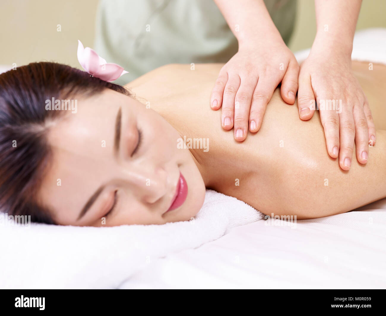 Junge asiatische Frau liegend auf der Vorderseite auf dem Bett, die Massage in der Spa. Stockfoto