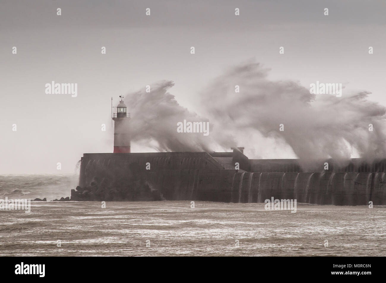 Newhaven, East Sussex, Großbritannien. Januar 2018. Wetter in Großbritannien. Starker Wind und reißender Regen an der Südküste. Die Wellen schlagen den Westarm und den Leuchtturm in den Pfennig. Stockfoto