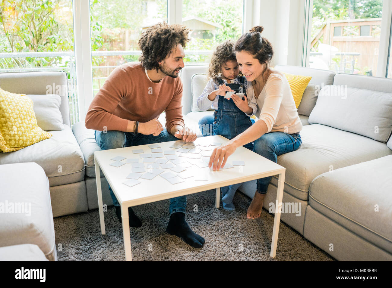 Familie sitzt auf der Couch und spielt Memory Spiel Stockfoto
