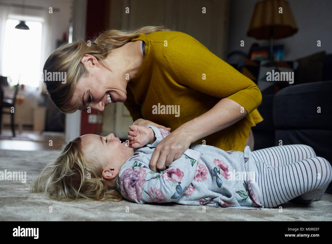 Mutter und Tochter gemeinsam amüsiert zu Hause Stockfoto