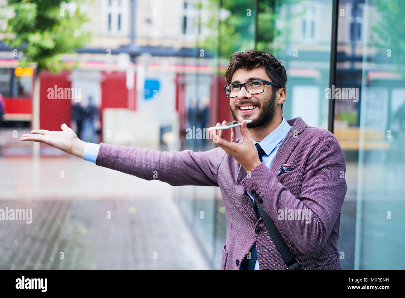 Portrait der junge Geschäftsmann am Telefon an einem regnerischen Tag Stockfoto