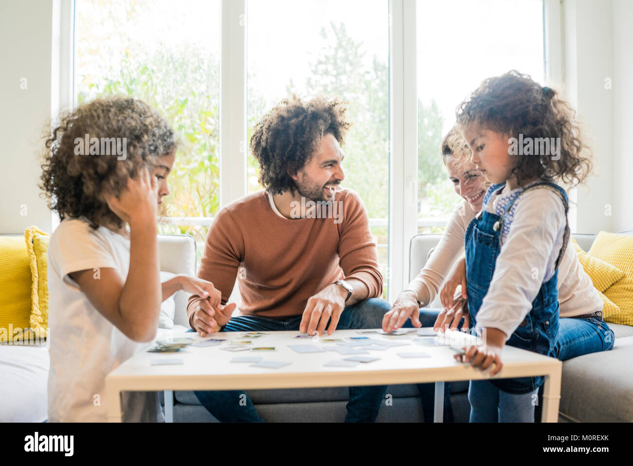 Familie sitzt auf der Couch und spielt Memory Spiel Stockfoto