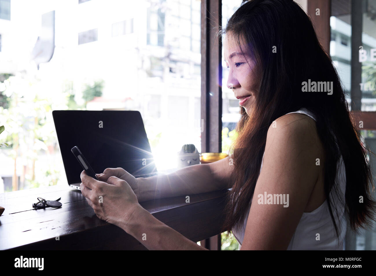 Senior brunette business lady Arbeiten mit Ihrem Handy und Laptop im Büro. Stockfoto