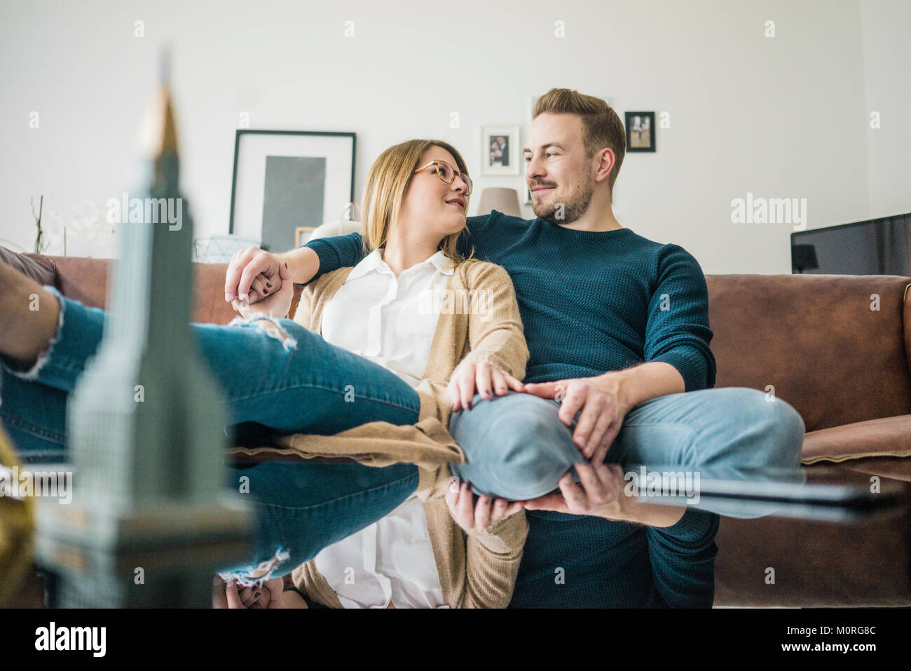 Paar auf der Couch zu Hause sitzen und das Modell des Empire State Building Stockfoto