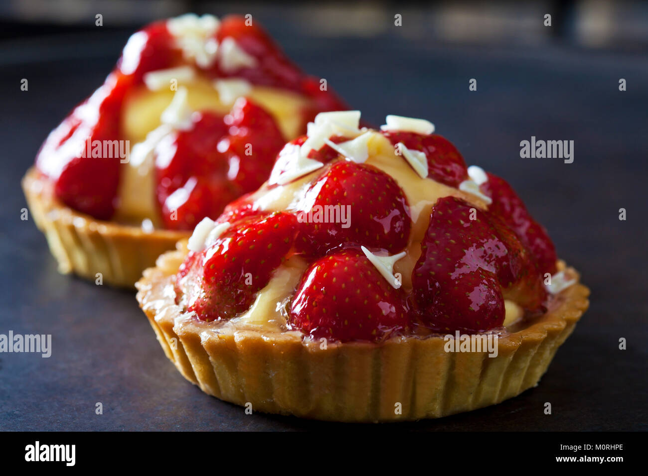 Erdbeere Törtchen mit Vanillepudding und weiße Schokolade rasieren Stockfoto