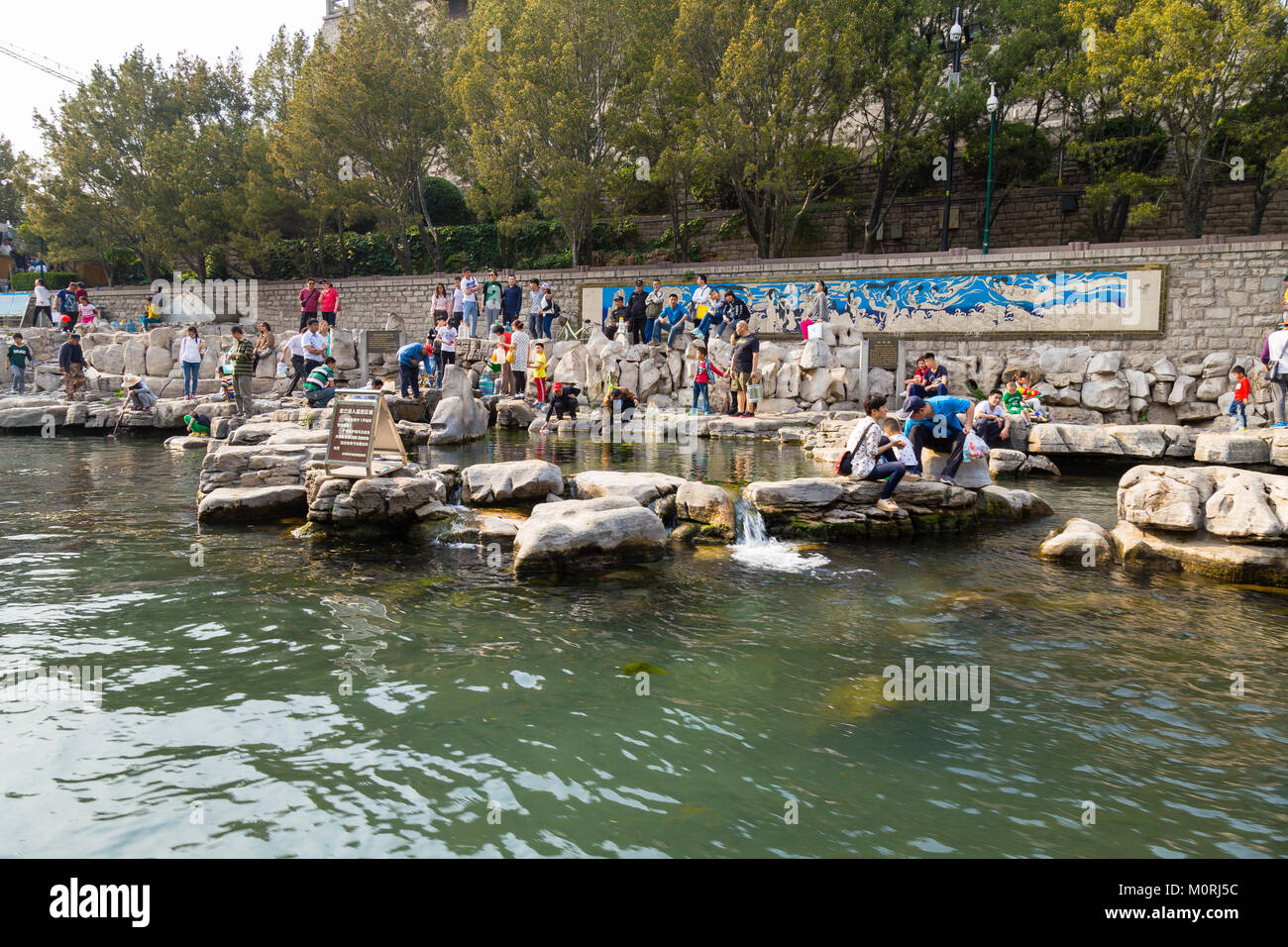 April 2015 - Jinan, China - lokale Leute, die Wasser aus einem der vielen Federn der Stadtgraben von Jinan Stockfoto